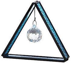 a triangle shaped bird feeder with a crystal ball hanging from it's side