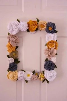 a white door with a wreath made out of paper flowers