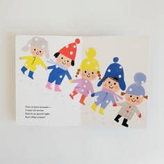 an open children's book with pictures of kids in winter clothes and hats on it