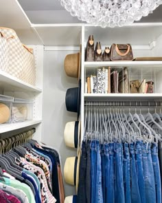 a closet filled with lots of clothes and handbags hanging from the ceiling next to shelves