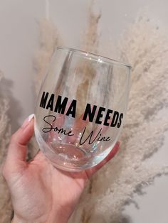 a hand holding a wine glass that says mama needs some wine