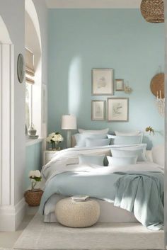 a bedroom with blue walls and white bedding in the corner, along with pictures on the wall