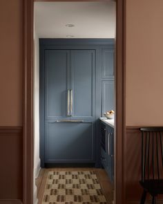 an open door leading to a kitchen with blue cabinets