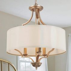 a chandelier hanging from a ceiling in a room with white walls and curtains