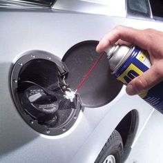 a person is filling up a can of soda into a car's fuel tank