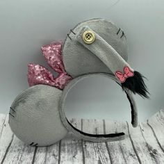 a gray mouse ears with pink bows and sequins