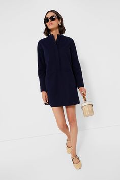 Elevate your capsule wardrobe with the Navy Twill Denim Wellington Dress. This mini is constructed from a structured organic cotton, featuring a crisp stand collar, front button placket with chest patch pockets, and long sleeves with long cuffs offering polished and elegant look. Exquisitely chic, we are pairing this number with everything from sneakers to sandals. Stand collar Long sleeves with long button cuffs Concealed front button placket Center back pleat Front patch pockets Side seam pock Cotton Shirt Dress With Buttoned Pockets For Fall, Fall Cotton Shirt Dress With Buttoned Pockets, Classic Cotton Shirt Dress For Fall, Spring Workwear Dresses With Patch Pockets, Chic Cotton Shirt Dress For Fall, Mini Shirt Dress With Button Cuffs For Workwear, Chic Fall Cotton Shirt Dress, Navy Shirt Dress For Spring Workwear, Fall Workwear Cotton Shirt Dress