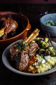 a plate with meat, mashed potatoes and brussel sprouts on it