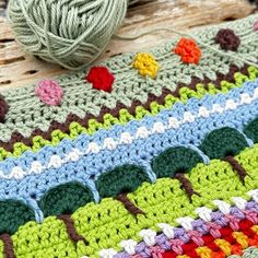 a crochet afghan with yarn and balls of yarn sitting on top of it