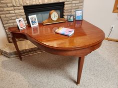 a wooden desk with pictures on it and a clock in the corner next to it