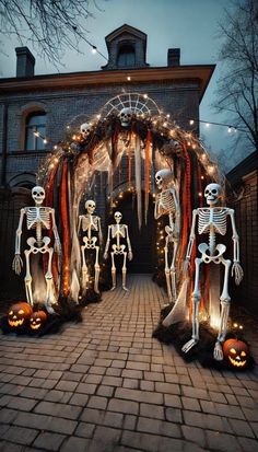 halloween decorations with skeletons and pumpkins in front of a brick walkway that leads to a house