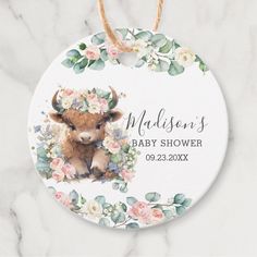 a baby shower ornament with an image of a cow and flowers on it