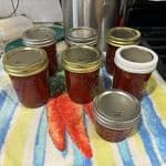 there are many jars and carrots on the table