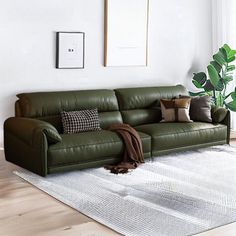 a living room with a green leather couch and white rug in front of the window