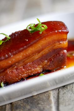 a close up of a plate of food with bacon and sauce on the side,