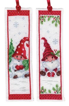 two cross stitch bookmarks with gnomes and holly leaves on the front, one is red