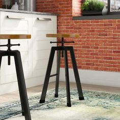 two stools sitting on top of a rug in front of a brick wall and floor