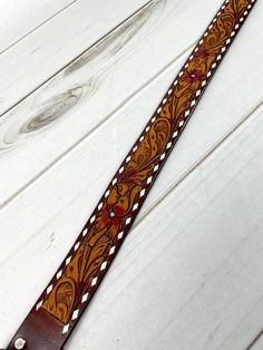 a brown leather belt sitting on top of a white wooden floor