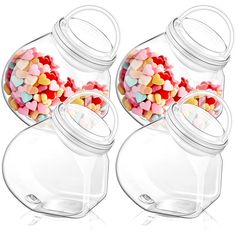 three glass jars filled with candy hearts on top of a white surface, side by side