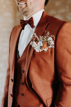 a man in a brown suit and flower boutonniere