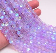 a hand holding a bunch of purple beads