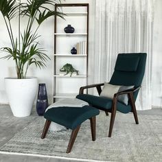 a chair and ottoman in a room with a potted plant on the far wall