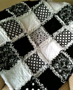 a black and white quilt is on the floor with an instagramr below it