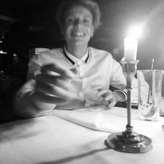 a woman sitting at a table with two candles in front of her