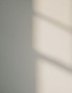 a black clock sitting on top of a table next to a white wall and window