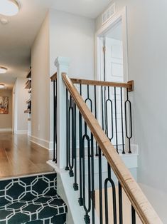 the stairs in this house are made of wood and wrought iron, while carpet is on the floor