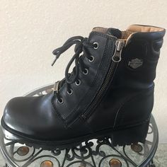 a pair of black boots sitting on top of a metal stand