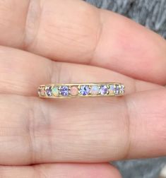 Natural Tanzanite Opal Alternating 3mm Half Eternity Band MaterialSolid Gold (14K/ 18K) or Platinum 950 FinishingHigh Polished/Shiny PlatingRhodium/Platinum Family (Only if white gold selected) FitStandard Fit Width3 mm Height1.8 mm SettingPave Prong Stone #1Natural Opal ShapeRound Cabochon ColorWhite with Fire-like hues of Orange, Yellow and Red Stone #2Natural Tanzanite ColorLavender with Purple and Blue Hues Cut & ShapeRound, Diamond Cut QualityAAA Click below to add laser engraving. http 14k Gold Eternity Band With Gemstone For Anniversary, 14k Gold Gemstone Eternity Band For Anniversary, Round Cut Birthstone Eternity Band For Anniversary, Gold Tanzanite Birthstone Ring For Anniversary, Birthstone Eternity Band For Anniversary, Eternity Band With Birthstone For Anniversary, Yellow Gold Tanzanite Birthstone Ring For Anniversary, Yellow Gold Eternity Band With Birthstone For Anniversary, Gold Tanzanite Wedding Ring