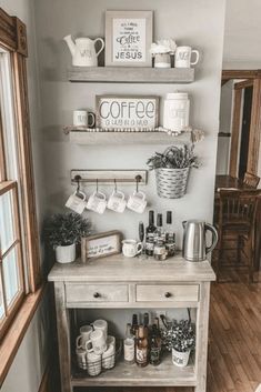 a coffee bar with cups and mugs on the shelves above it, along with other items