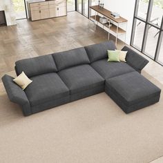 a large gray couch sitting on top of a wooden floor next to a living room