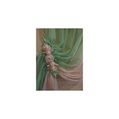 the curtains are covered with green and pink fabric, flowers on each side of the drapes