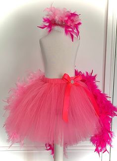 a pink tutule and headband on top of a mannequin