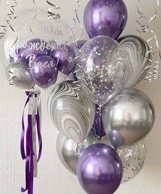 purple and silver balloons are hanging from the ceiling