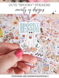 a person holding up a sticker with the words spooky season on it