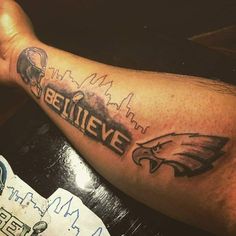 a man's arm with an eagle and the word believe tattooed on it in black ink