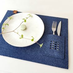 a white plate and fork on a blue place mat