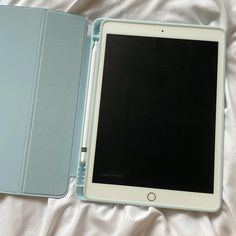 an ipad case sitting open on top of a bed