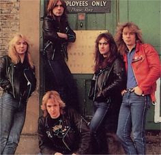 the group of young men are posing for a photo in front of a green door