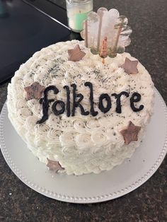 a cake that is sitting on a plate with the word folklore spelled in black letters