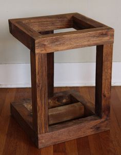 a wooden box sitting on top of a hard wood floor next to a white wall