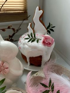 there is a cake with icing and flowers on the plate next to other decorations