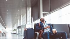 a man sitting in an airport waiting for his flight