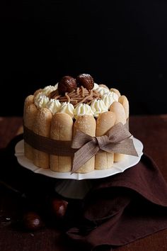 a cake with white frosting and chocolate toppings on top, sitting on a plate