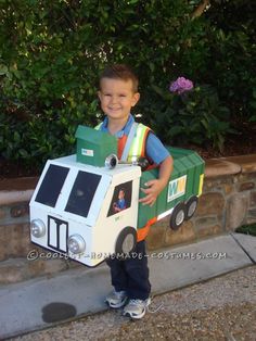 a young boy wearing a costume made to look like a train conductor with a cardboard box on his head