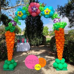 an arch made out of balloons with flowers and butterflies on it is in the shape of carrots