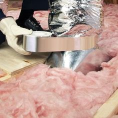 a man sitting on top of a wooden floor covered in pink fluffy material and wearing black shoes